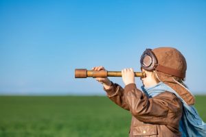 young girl outside looking through telescope