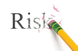 Mitigating business investment risk. pencil eraser erasing the word Risk