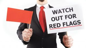 Man in a suit holding a red flag, mistakes to avoid when hiring a certified financial planner in the d.c. area