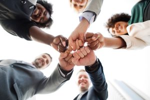 Group of people touching hands, wealth management firm should be a partner in your financial life